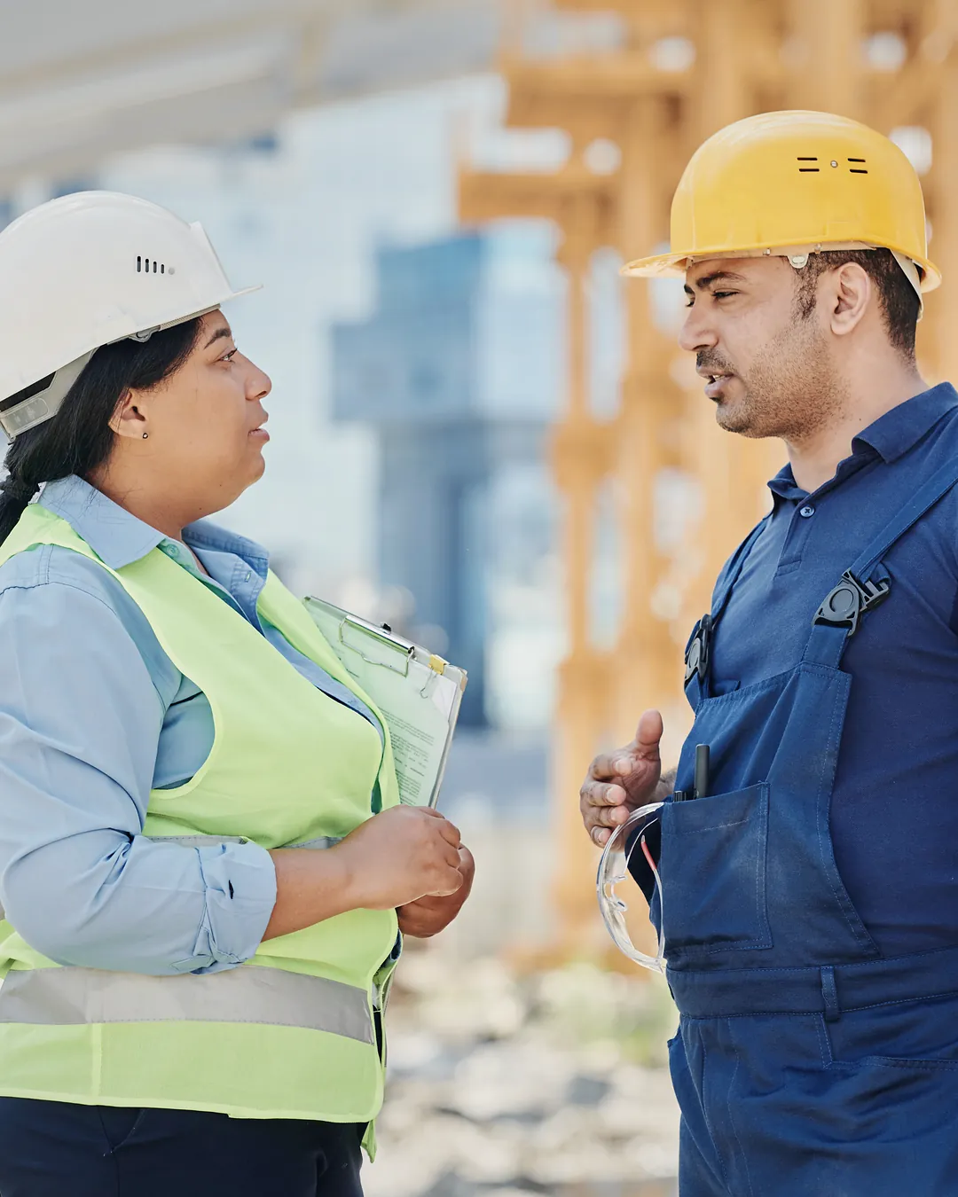 A site supervisor and a foreman in hard hats talking on a construction site